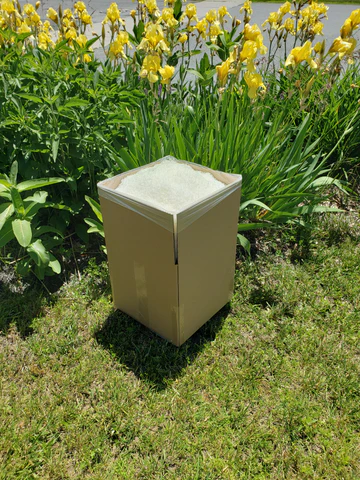A cubic foot box with a plastic liner full of white Ecofetti presented in front of orange iris flowers